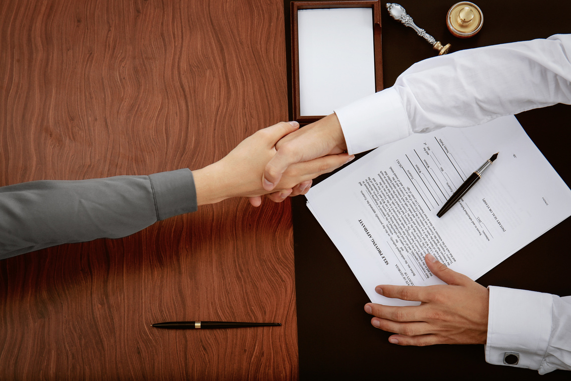 Client and Lawyer Shaking Hands over the Notary Table